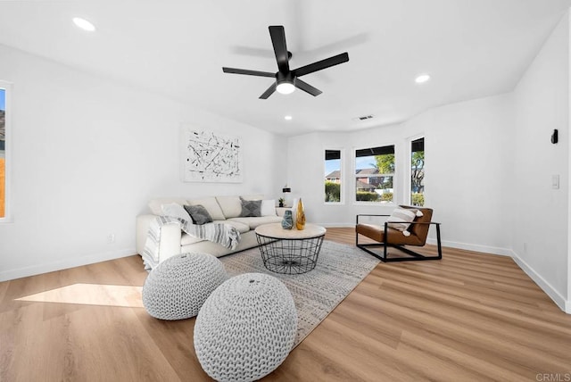 living area with recessed lighting, visible vents, baseboards, and wood finished floors