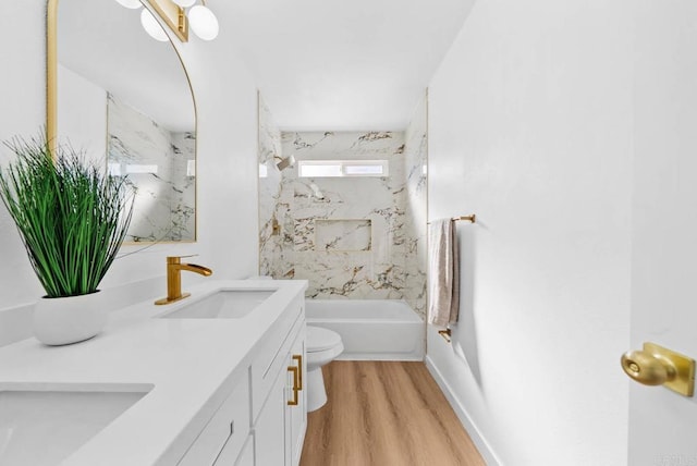 bathroom featuring double vanity, a combined bath / shower with marble appearance, toilet, wood finished floors, and a sink