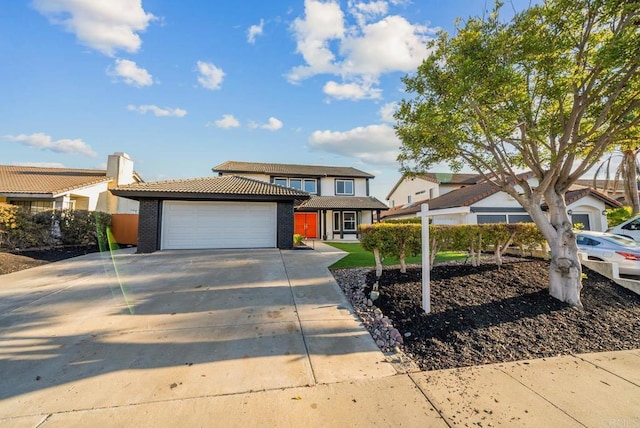 traditional home featuring a garage, concrete driveway, and brick siding