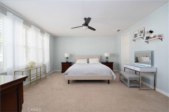 bedroom featuring light carpet, ceiling fan, visible vents, and baseboards