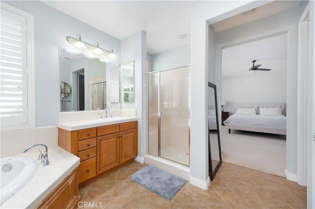 ensuite bathroom featuring tile patterned flooring, a shower stall, a bath, and vanity