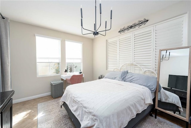 bedroom featuring baseboards and an inviting chandelier