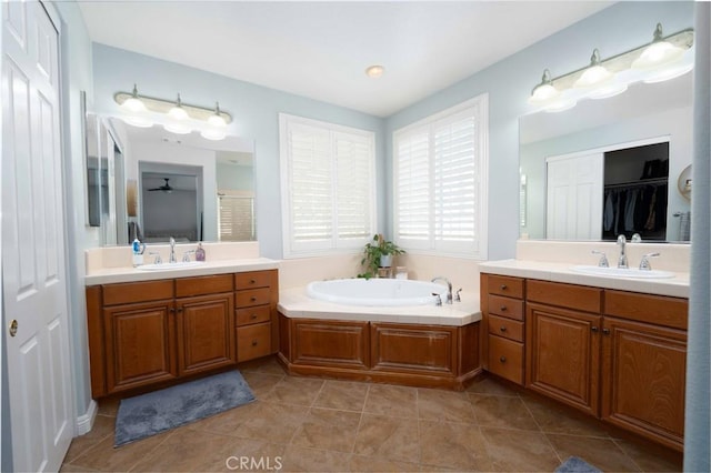 full bath featuring a closet, two vanities, and a sink