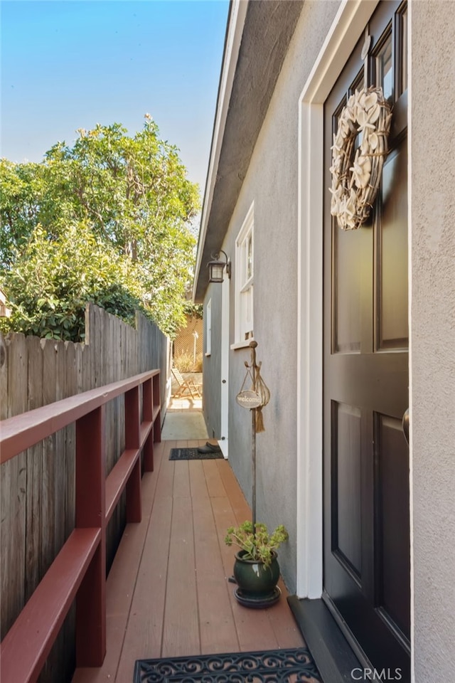 view of side of home featuring fence and stucco siding