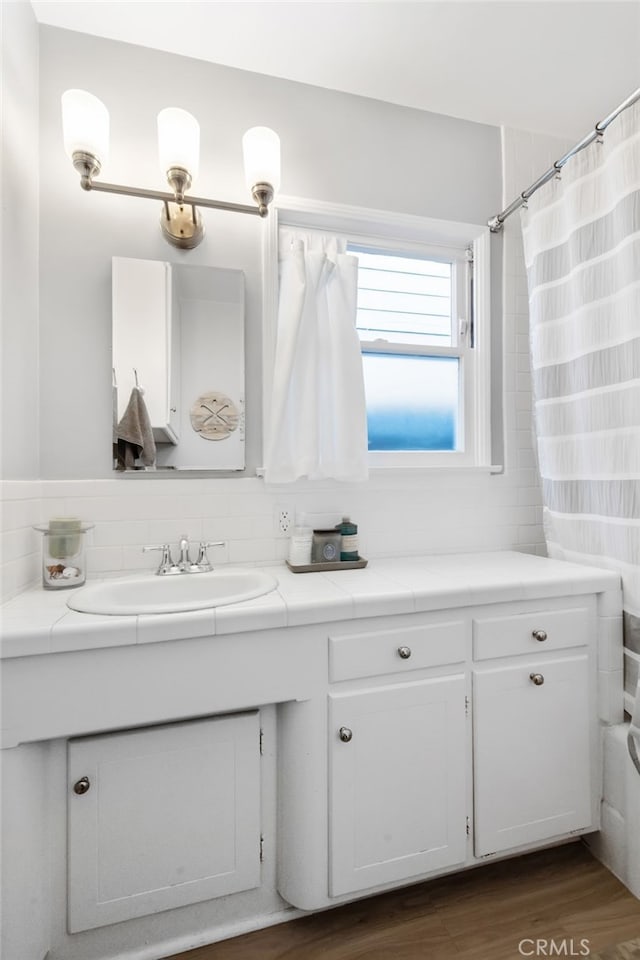 full bathroom with tasteful backsplash, vanity, a shower with shower curtain, and wood finished floors