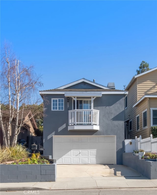 view of front of home with stucco siding, concrete driveway, an attached garage, fence, and a balcony