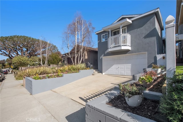 view of front of property featuring a balcony, a garage, concrete driveway, and stucco siding