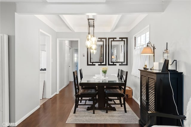 dining room featuring beam ceiling, baseboards, and wood finished floors