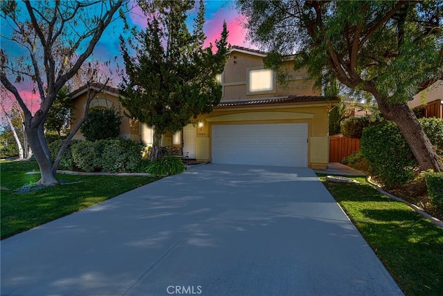 view of front facade featuring a garage, fence, a tile roof, driveway, and stucco siding