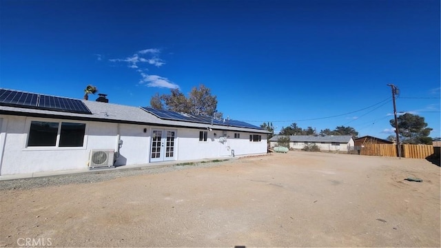 420 N Yorktown St, Ridgecrest, CA 93555 - rear view of property with fence, french doors, ac unit, roof mounted solar panels, and stucco siding
