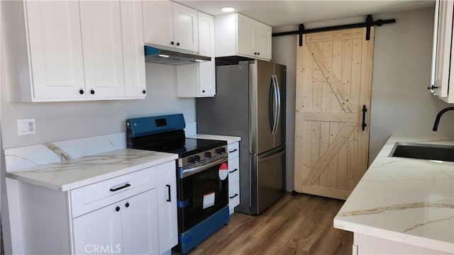 420 N Yorktown St, Ridgecrest, CA 93555 - kitchen featuring a barn door, under cabinet range hood, a sink, white cabinetry, and appliances with stainless steel finishes