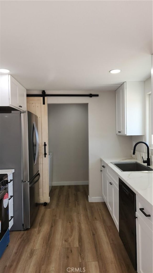 420 N Yorktown St, Ridgecrest, CA 93555 - kitchen with a barn door, white cabinetry, a sink, wood finished floors, and black appliances