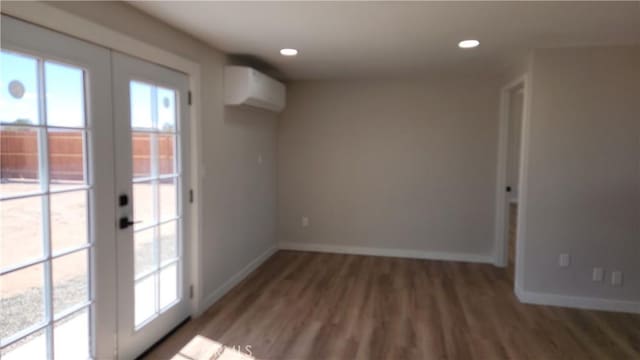420 N Yorktown St, Ridgecrest, CA 93555 - spare room featuring baseboards, wood finished floors, a wall mounted air conditioner, french doors, and recessed lighting