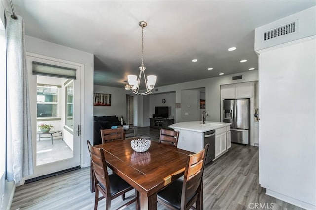 dining room featuring light wood finished floors, visible vents, a chandelier, and recessed lighting