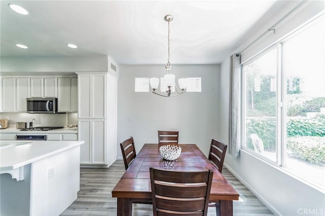 dining room featuring baseboards, visible vents, an inviting chandelier, light wood-type flooring, and recessed lighting