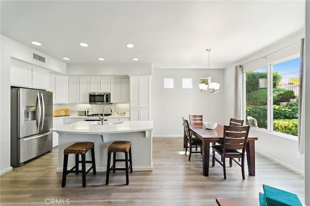 kitchen with visible vents, appliances with stainless steel finishes, light countertops, white cabinetry, and a sink