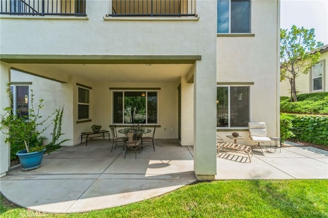 back of property with a patio area and stucco siding