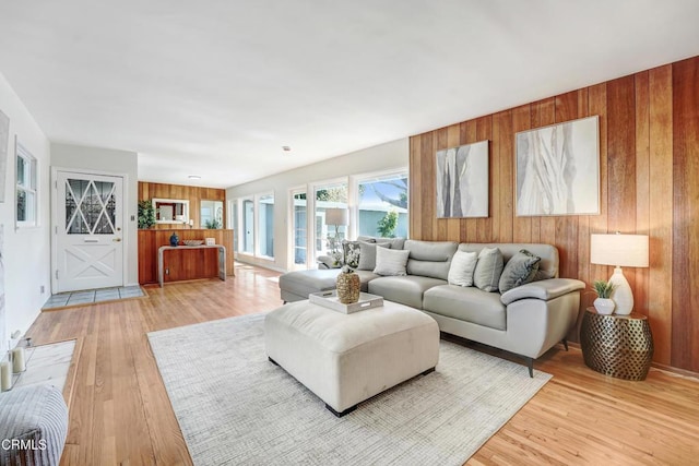 living room featuring wood walls and light wood-style flooring