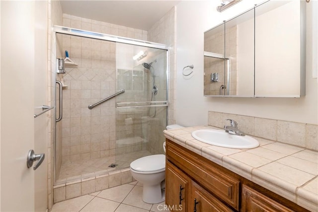 full bath with toilet, a stall shower, tile patterned floors, and vanity