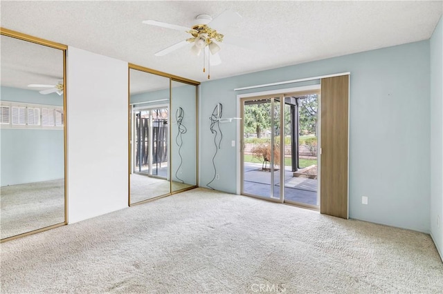 empty room featuring a ceiling fan, carpet flooring, and a textured ceiling