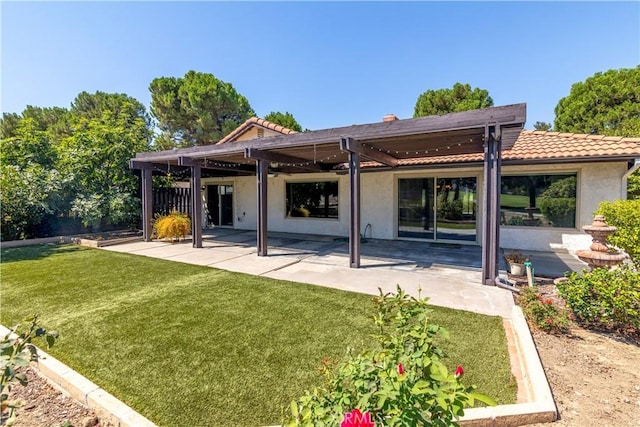 rear view of house with a patio, a tile roof, a yard, a pergola, and stucco siding