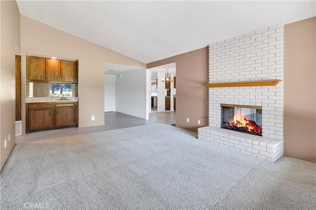 unfurnished living room featuring light carpet, vaulted ceiling, a fireplace, and visible vents