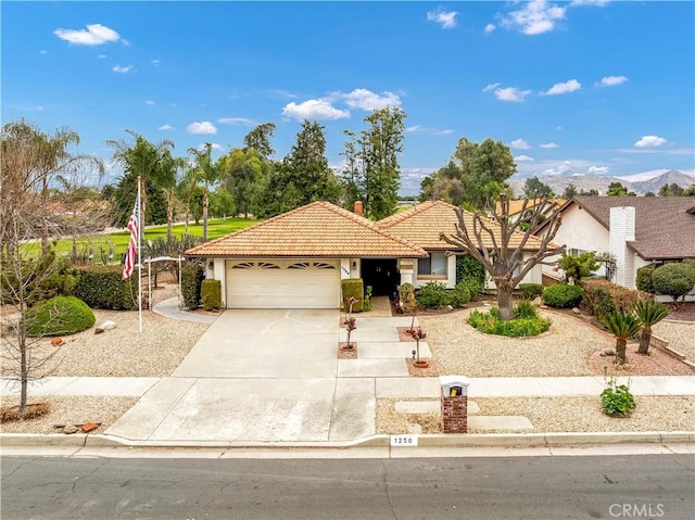 view of front of home with a garage, a tiled roof, concrete driveway, stucco siding, and a chimney