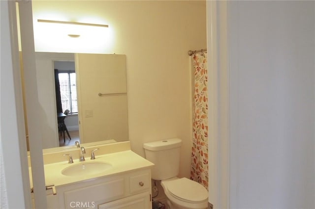 bathroom featuring toilet, a shower with curtain, and vanity