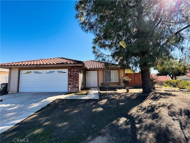 25501 Sand Creek Trl, Moreno Valley, CA 92557 - view of front of property with a tile roof, concrete driveway, fence, and a garage