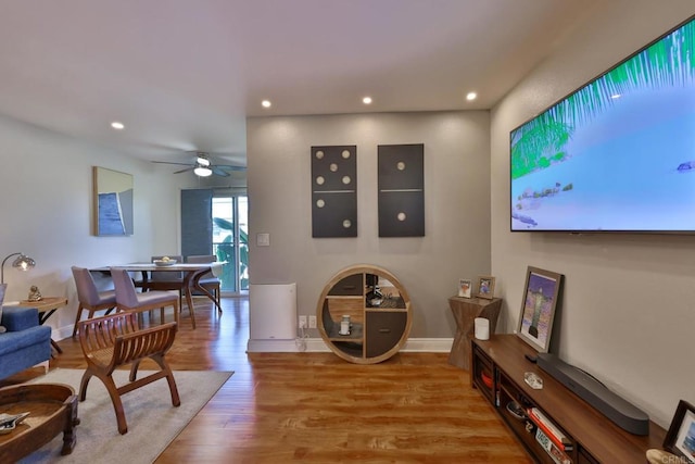 living area featuring ceiling fan, baseboards, wood finished floors, and recessed lighting