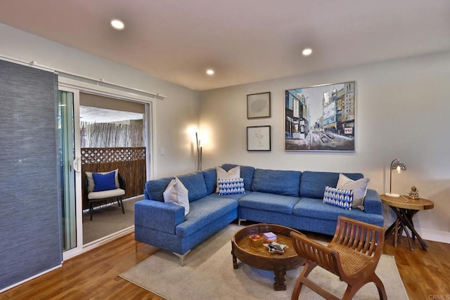 living area featuring baseboards, wood finished floors, and recessed lighting