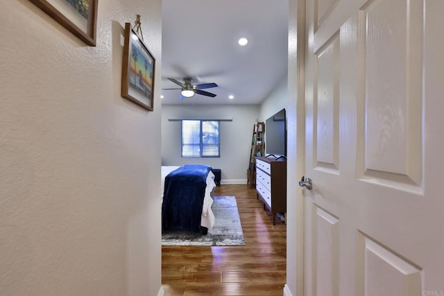 bedroom featuring baseboards, wood finished floors, and recessed lighting