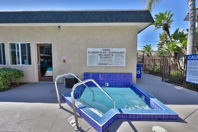 view of swimming pool with a patio and fence