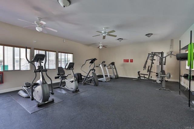 exercise room with ceiling fan and baseboards