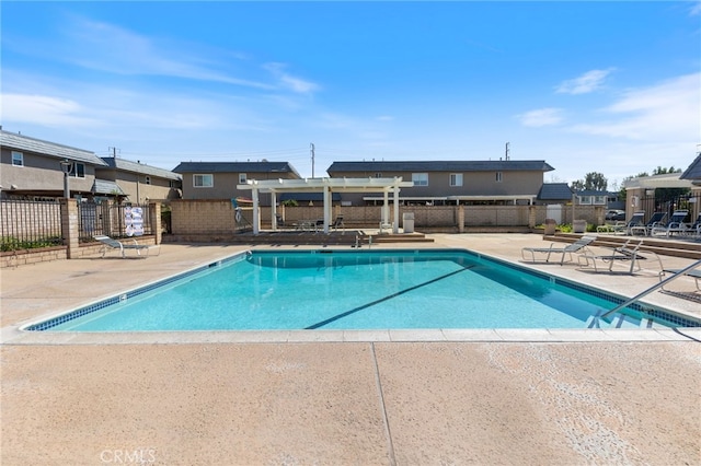 pool with a patio, fence, and a pergola