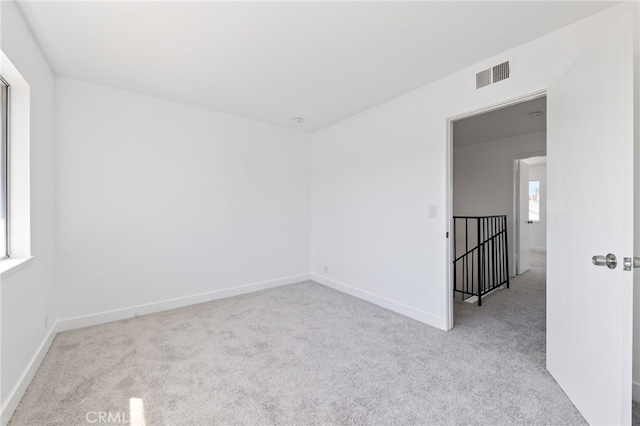 carpeted empty room with baseboards and visible vents