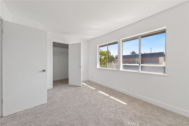 unfurnished bedroom with carpet, a closet, and baseboards