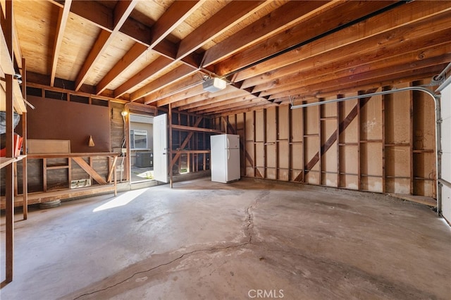 misc room with a garage and unfinished concrete flooring