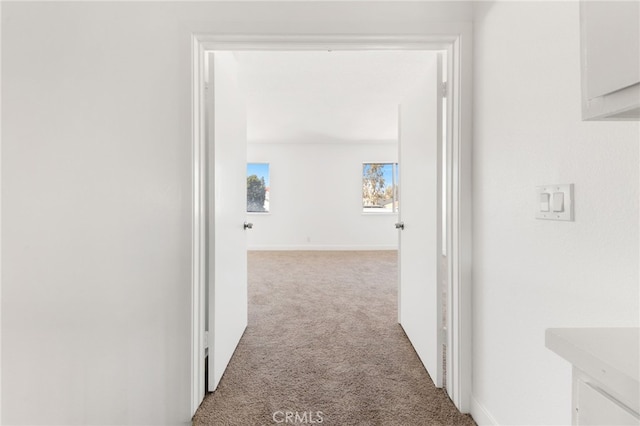 corridor with carpet and baseboards