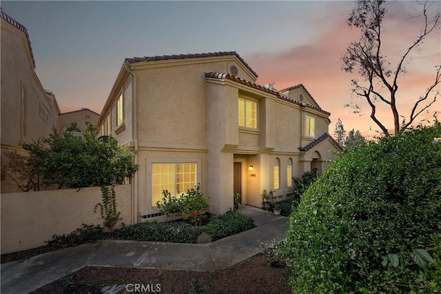 mediterranean / spanish-style house featuring a tile roof and stucco siding