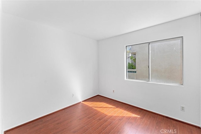 unfurnished room with wood finished floors