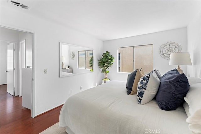 bedroom featuring visible vents and wood finished floors