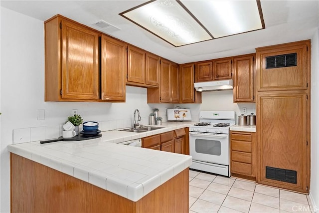 kitchen featuring white gas range oven, a sink, visible vents, and under cabinet range hood