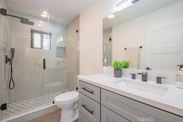 bathroom featuring vanity, tile patterned flooring, a shower stall, and toilet