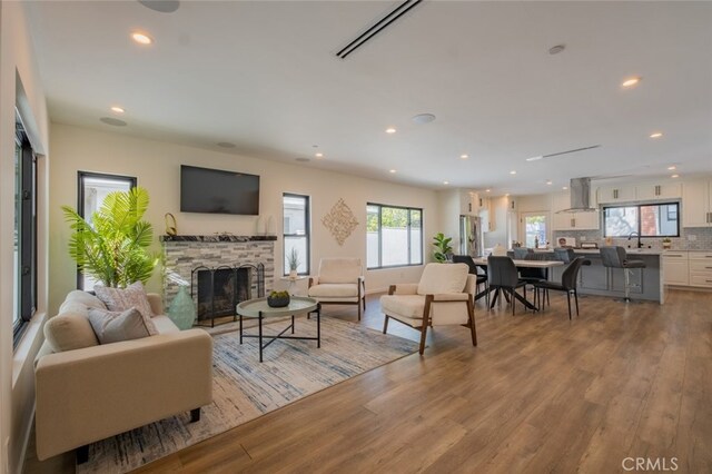 living room with recessed lighting, a fireplace, and wood finished floors