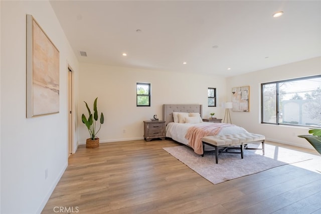 bedroom with light wood-style flooring, visible vents, baseboards, and recessed lighting
