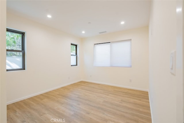 spare room with light wood-style flooring, visible vents, baseboards, and recessed lighting