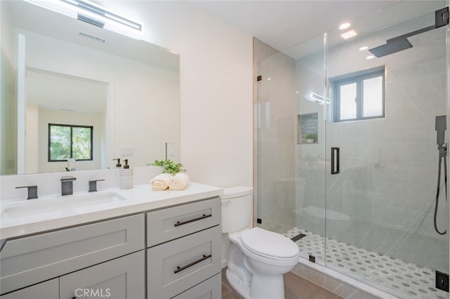 bathroom featuring toilet, a shower stall, visible vents, and vanity