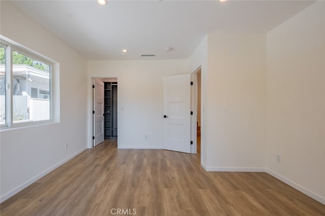 unfurnished room featuring light wood-style flooring, visible vents, baseboards, and recessed lighting
