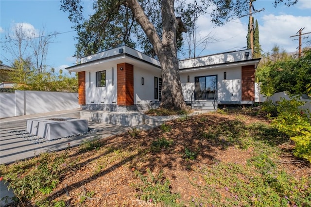 back of property featuring entry steps and fence